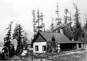 F. Malkin, his wife, and a small child behind their house at King Edward Bay.  J.F. Malkin is sitting on the stump. ca. 1900’s